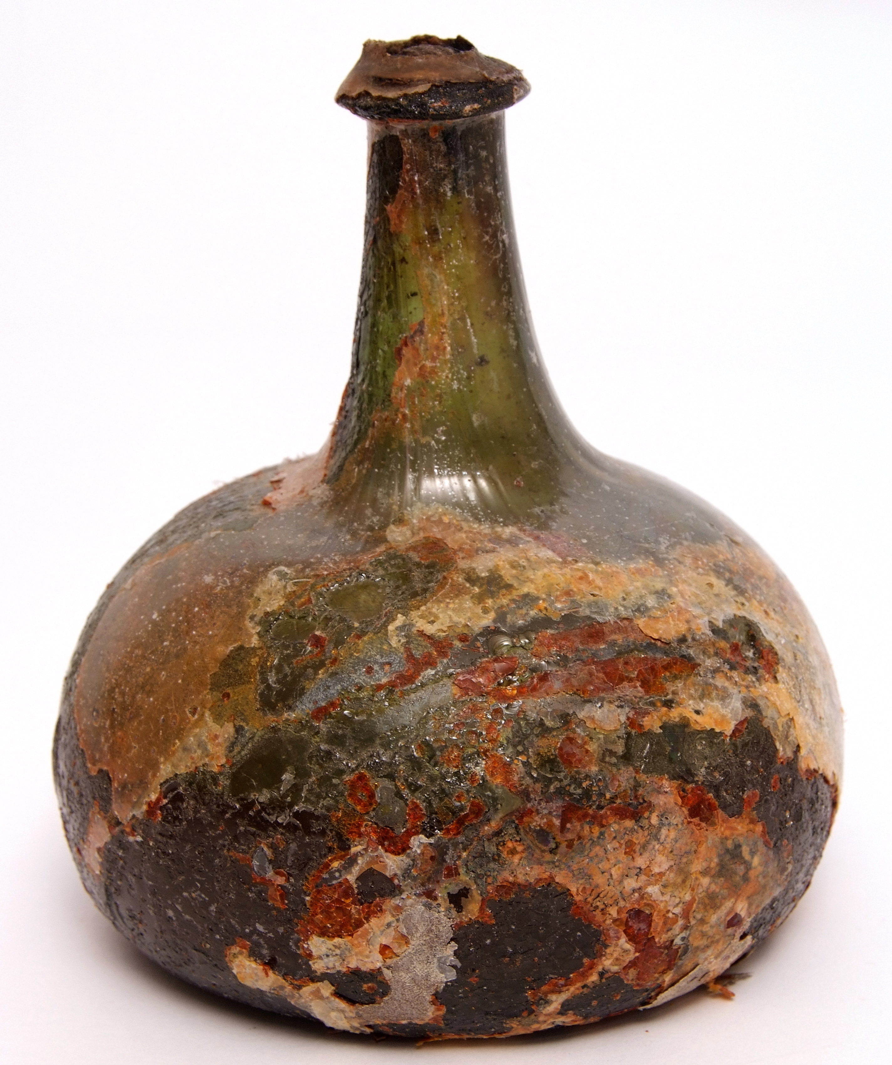 Late 17th century onion glass wine bottle with original stopper and contents, 16cm high