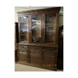 LATE 19TH CENTURY OAK BOOKCASE WITH THREE LEADED AND GLAZED DOORS, THE BASE FITTED WITH THREE