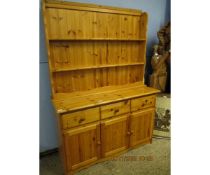 STAINED PINE DRESSER WITH TWO FIXED SHELVES WITH THREE DRAWERS OVER THREE PANELLED CUPBOARD DOORS