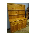 STAINED PINE DRESSER WITH TWO FIXED SHELVES WITH THREE DRAWERS OVER THREE PANELLED CUPBOARD DOORS