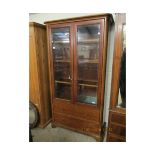 CHERRY WOOD BOOKCASE WITH TWO GLAZED DOORS OVER TWO FULL WIDTH DRAWERS WITH BRASS BUTTON HANDLES