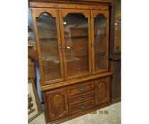 OAK EFFECT BOOKCASE WITH THREE GLAZED DOORS TO TOP, THE BASE FITTED CENTRALLY WITH THREE DRAWERS