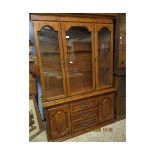 OAK EFFECT BOOKCASE WITH THREE GLAZED DOORS TO TOP, THE BASE FITTED CENTRALLY WITH THREE DRAWERS