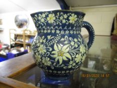 THUNE POTTERY JUG, THE BLUE GROUND DECORATED IN WHITE WITH FLORAL SPRAYS, 12CM HIGH