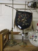 TWO BRASS TABLE SCREENS, ONE WITH EMBROIDERED PANEL