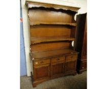 TEAK EFFECT DRESSER WITH TWO FIXED SHELVES, THE BASE WITH THREE DRAWERS OVER THREE PANELLED CUPBOARD