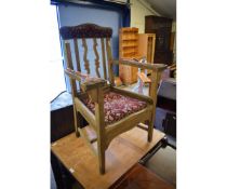 OAK FRAMED ARMCHAIR WITH RED UPHOLSTERED ARMS AND TOP RAIL