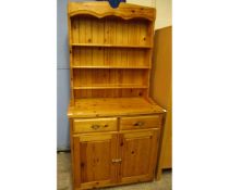 PINE FRAMED DRESSER BASE FITTED WITH TWO DRAWERS OVER CUPBOARD DOORS WITH BRASS HANDLES