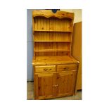 PINE FRAMED DRESSER BASE FITTED WITH TWO DRAWERS OVER CUPBOARD DOORS WITH BRASS HANDLES