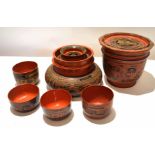 Group of Oriental red lacquer wares with various geometric and chinoiserie designs, comprising small