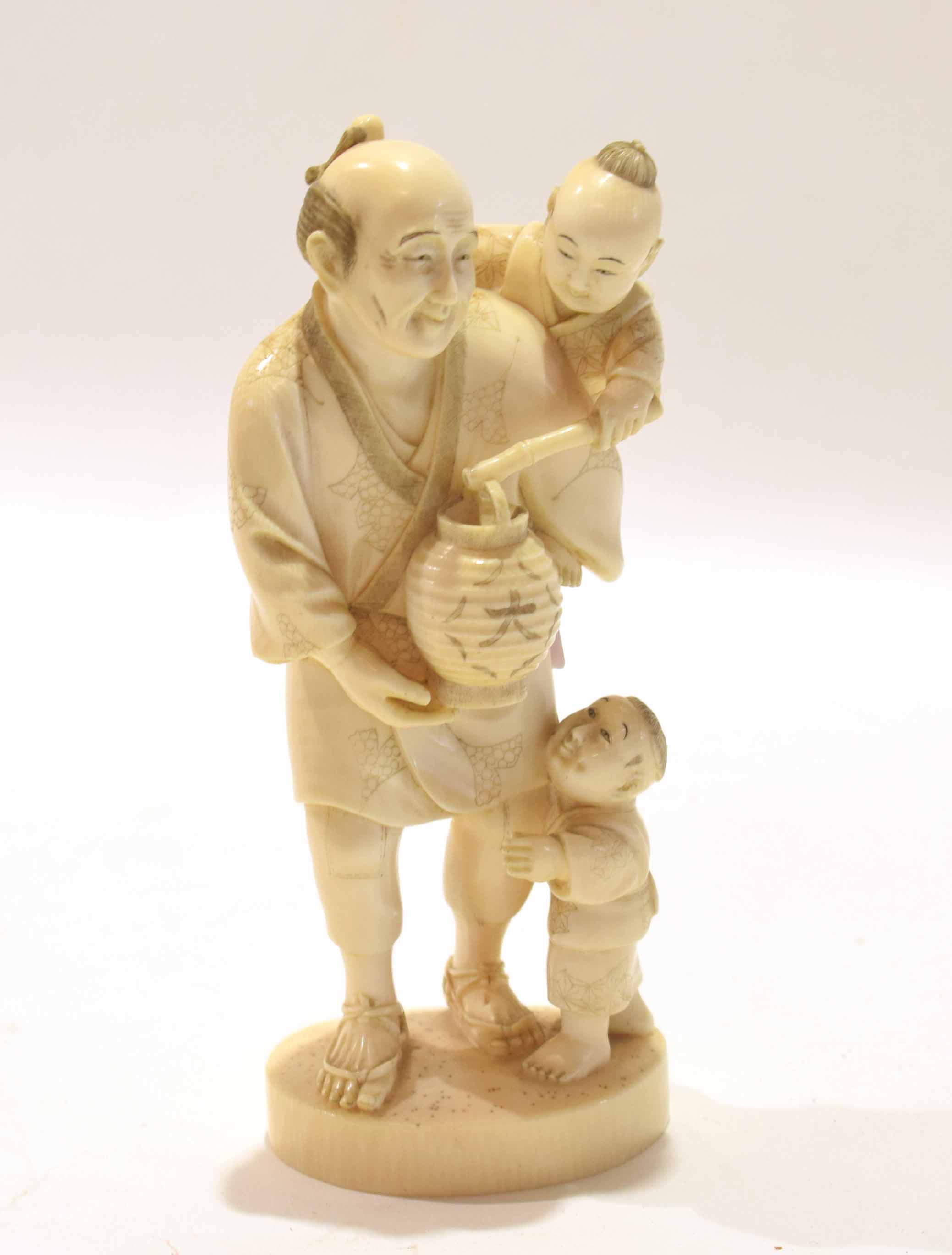 Japanese ivory figure of a man with two children, Meiji period, with one child on his back and