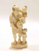 Japanese ivory figure of a man with two children, Meiji period, with one child on his back and