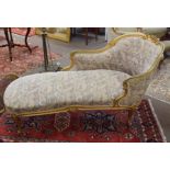 Giltwood chaise longue, swept back encrusted with C-scroll and foliage, upholstered in floral print,