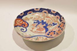 Large Japanese porcelain Imari dish with typical designs and a shaped rim, the underneath with