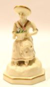 Early 19th century Rockingham style figure of a lady with basket of flowers