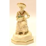 Early 19th century Rockingham style figure of a lady with basket of flowers