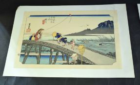 Two Japanese wood block prints, one by Utagawa of children crossing a bridge, the other of a village