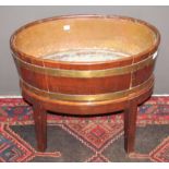 Early 19th century mahogany brass bound planter of oval form with tin liner, raised on a later stand