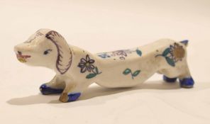 Dutch Delft knife rest, modelled as a dachshund with floral design