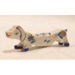 Dutch Delft knife rest, modelled as a dachshund with floral design