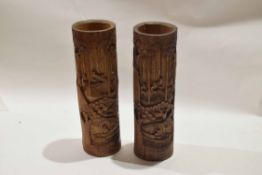 Pair of bamboo carved brush holders, carved with figures in various pursuits, 35cm high (2)