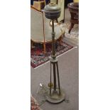 Brass adjustable standard lamp (converted to electricity) raised on pointed feet in the Arts &