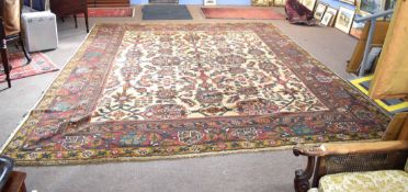 20th century large Indian carpet, a central panel of geometric floral decoration within a multi-gull