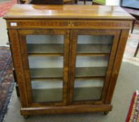 Mahogany and walnut inlaid bookcase with two glazed doors enclosing fitted shelving on peg feet,