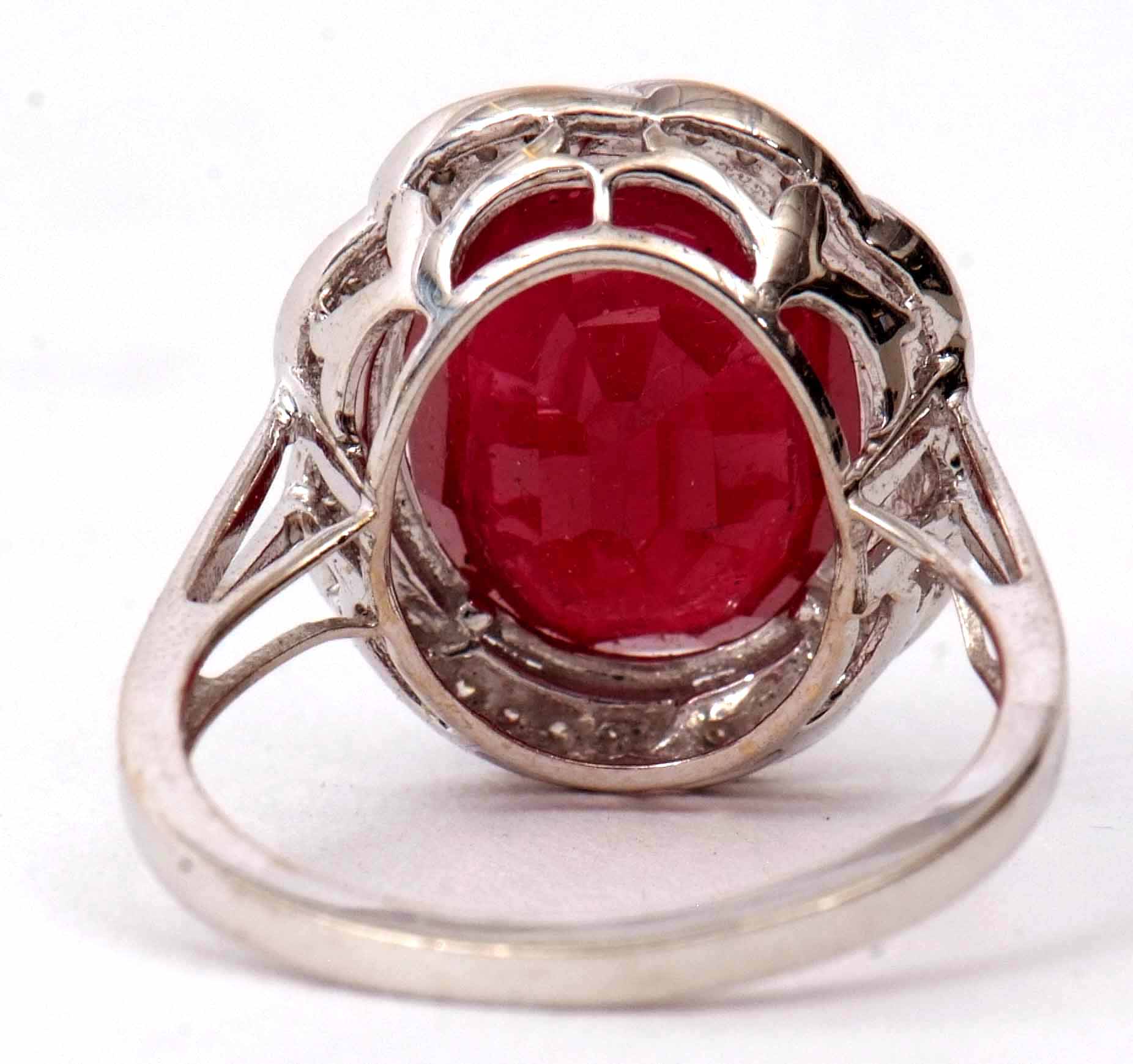 Modern ruby and diamond cluster ring, the oval faceted ruby 12 x 10mm, within a surround of small - Image 3 of 3