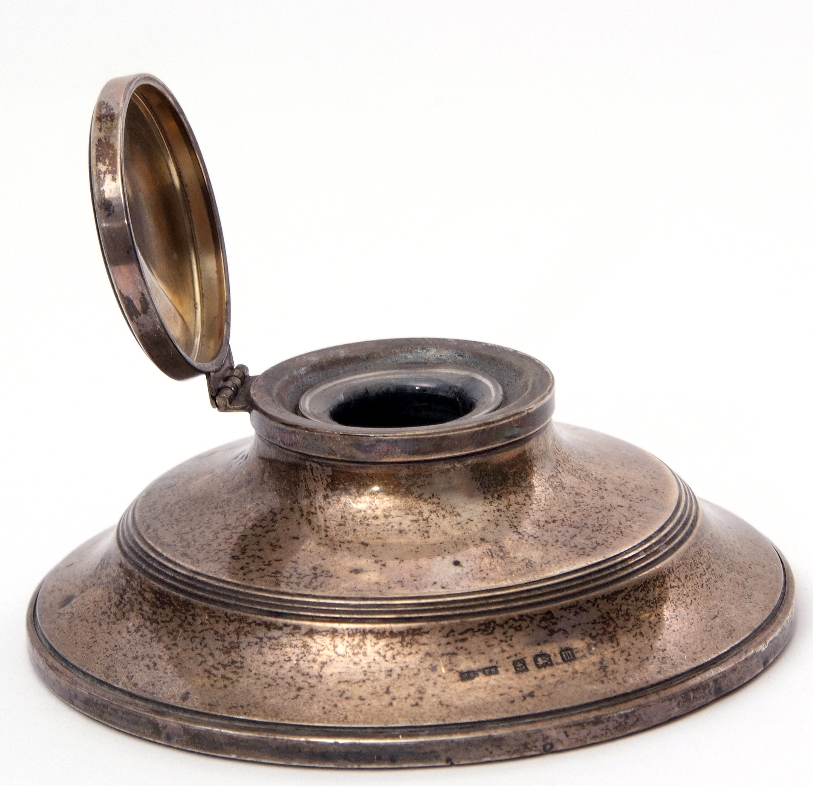 George V circular silver encased capstan inkwell with hinged lid, complete with internal glass