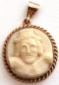 Antique carved ivory circular pendant, a symbolist portrait of Christ, framed in a later yellow