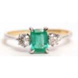 Emerald and diamond three stone ring, the rectangular shaped centre emerald 6 x 4mm, flanked by 2