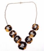 Faux tortoiseshell necklace featuring seven octagonal shaped plaques, each inlaid with palm trees,