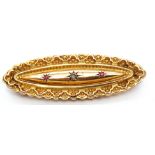 Early 20th century 9ct gold diamond and ruby brooch, the elongated scroll and bead brooch centring a