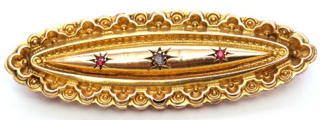 Early 20th century 9ct gold diamond and ruby brooch, the elongated scroll and bead brooch centring a