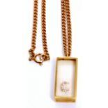 Modern yellow metal and glazed pendant with the letter "G" in brilliant white stones, suspended from