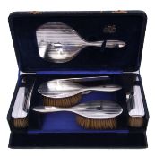 Cased six piece silver backed dressing table set comprising a hand mirror, two hair brushes, a