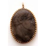 Antique carved lava cameo pendant, oval shaped, depicting a head and shoulders profile of a man,