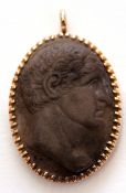 Antique carved lava cameo pendant, oval shaped, depicting a head and shoulders profile of a man,