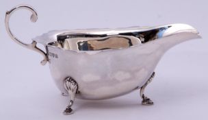 George V sauce boat in early Georgian style, having card cut rim, flying scrolled handle and