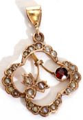 9ct stamped open work pendant set with a small garnet and highlighted with seed pearls throughout