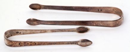 Two pairs of Georgian Old English pattern sugar tongs, the first with bright cut decoration,