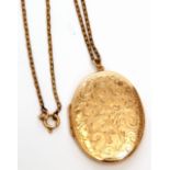 9ct gold oval locket, the front chased with a floral scroll design, 4 x 3cm, suspended from a gilt