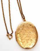 9ct gold oval locket, the front chased with a floral scroll design, 4 x 3cm, suspended from a gilt