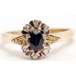 18ct gold sapphire and diamond cluster ring, the dark oval faceted sapphire set between six small