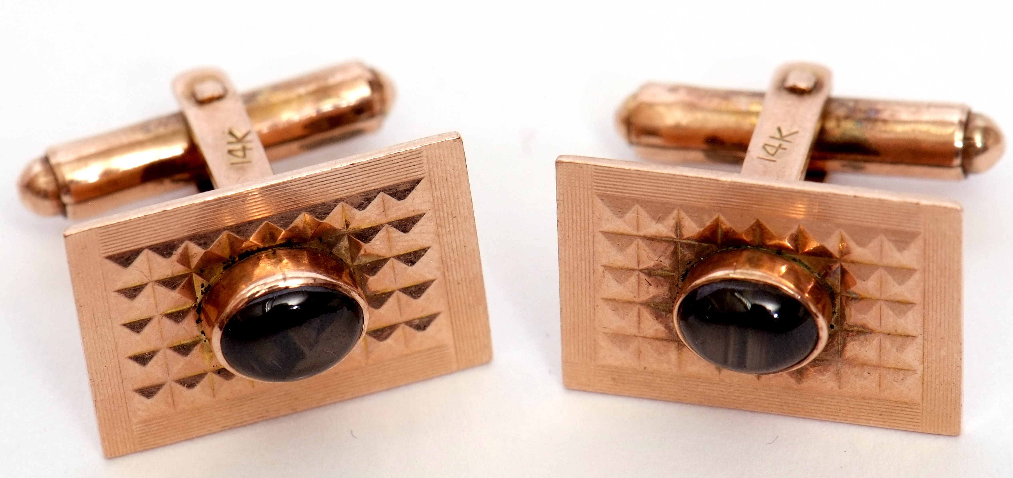 Pair of 14k stamped stylised cuff links each centring an oval cabochon tiger's eye stone, raised