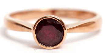 9ct stamped garnet single stone ring, the circular faceted garnet bezel set and raised in a plain