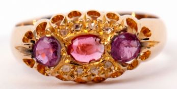 Early 20th century 18ct gold, ruby and diamond ring centring an oval shaped ruby between two