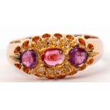 Early 20th century 18ct gold, ruby and diamond ring centring an oval shaped ruby between two