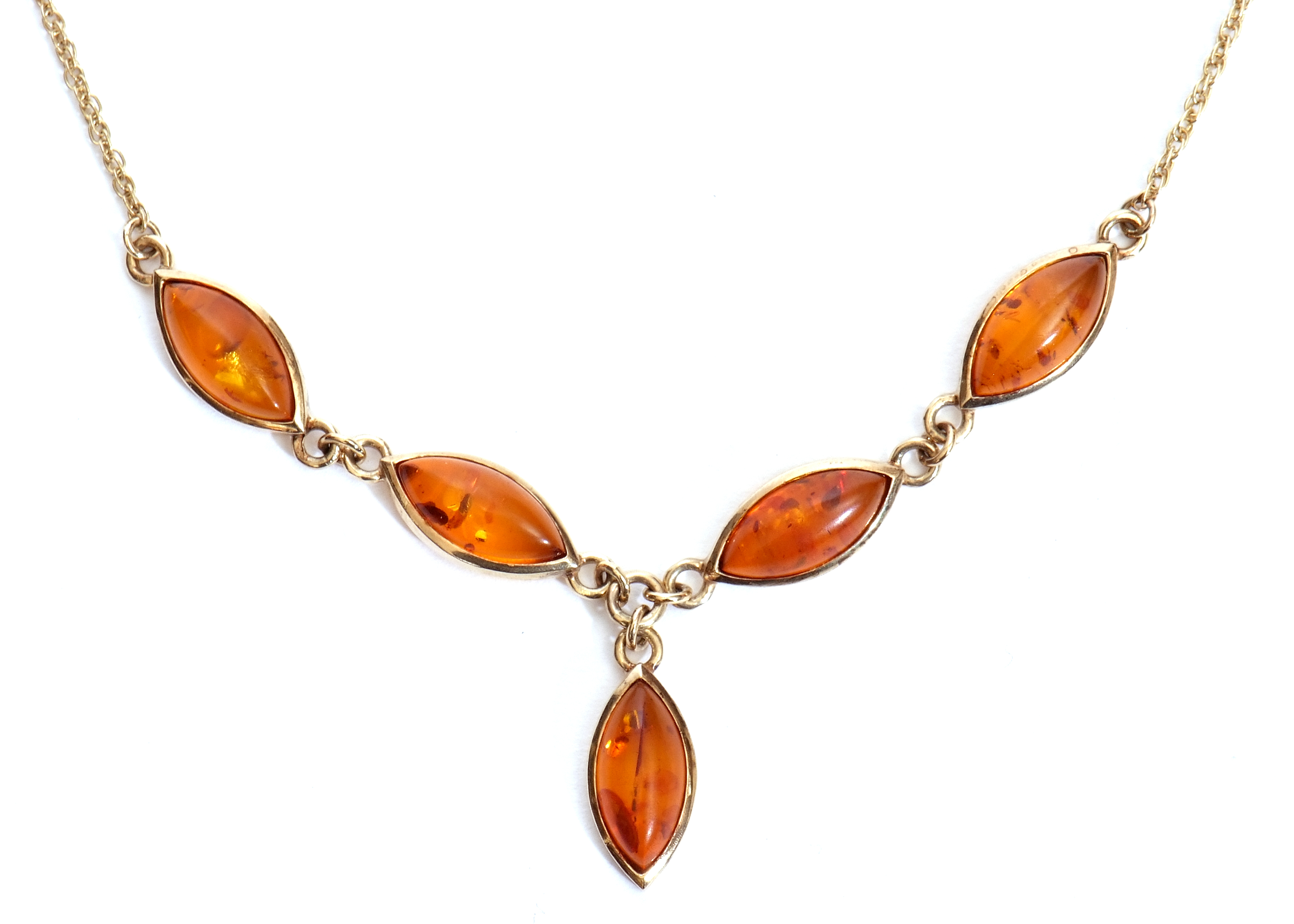 Modern yellow metal and amber necklace, a design featuring four lozenge shaped links and a